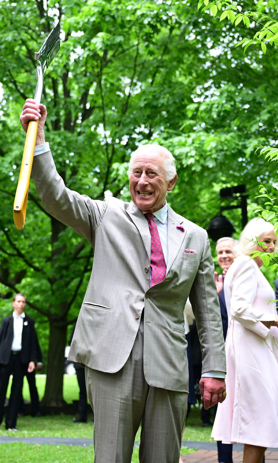 King Charles holding a shovel in the air