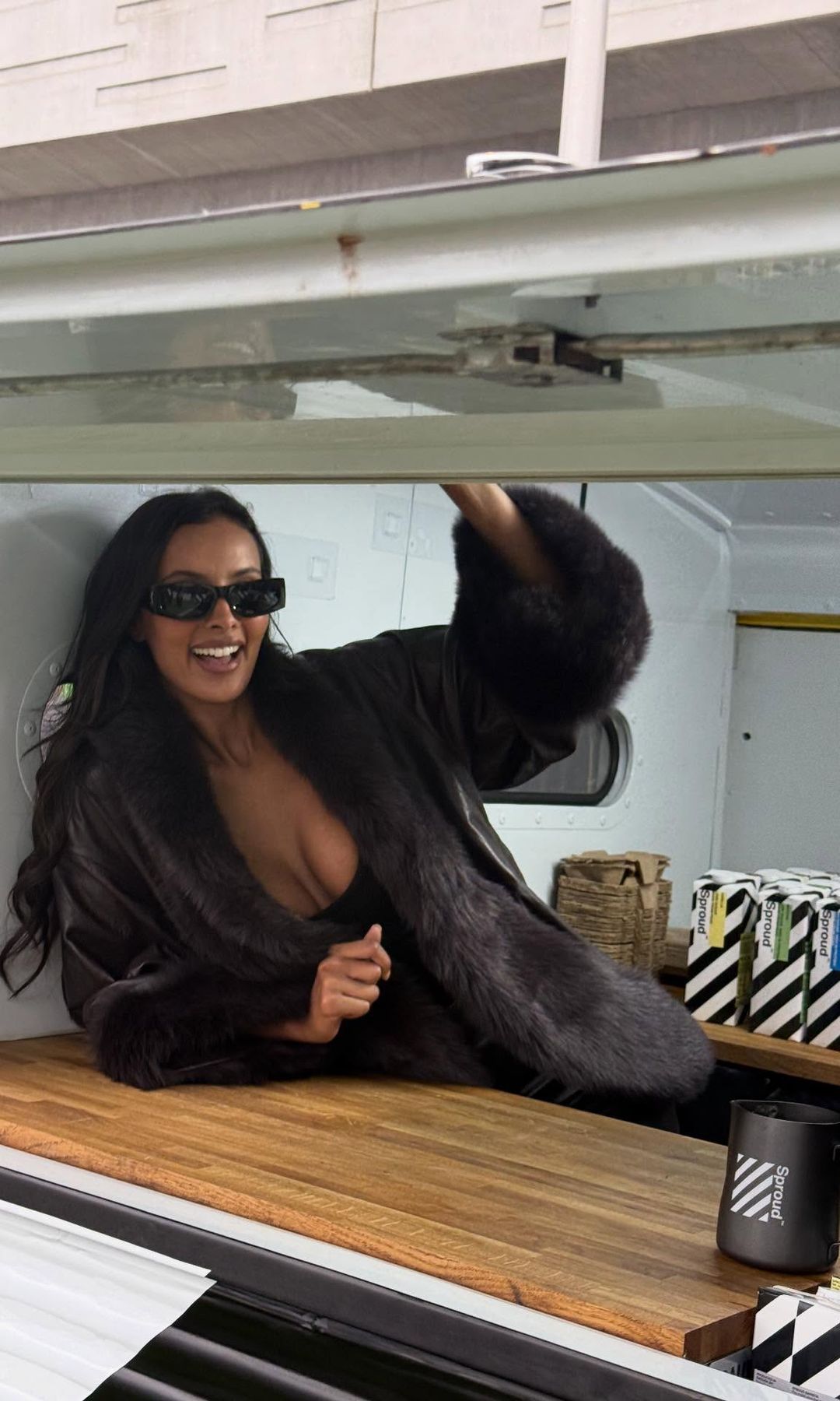 Maya Jama poses in a brown leather coat