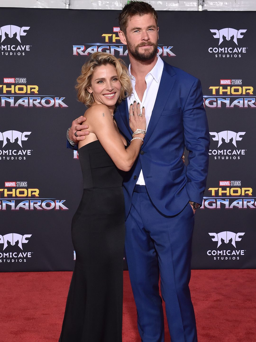Chris Hemsworth and Elsa Pataky posing together on a red carpet, smiling at the camera