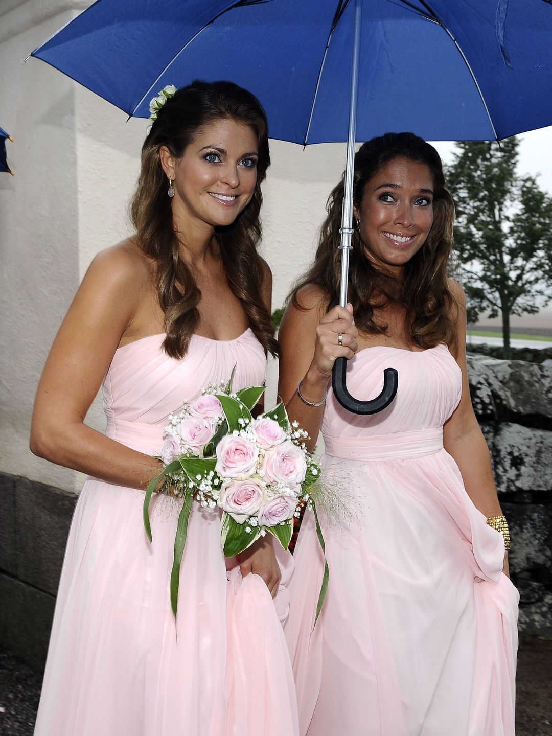 Princess Madeleine and Louise Gottlieb underneath an umbrella in bridesmaid dresses