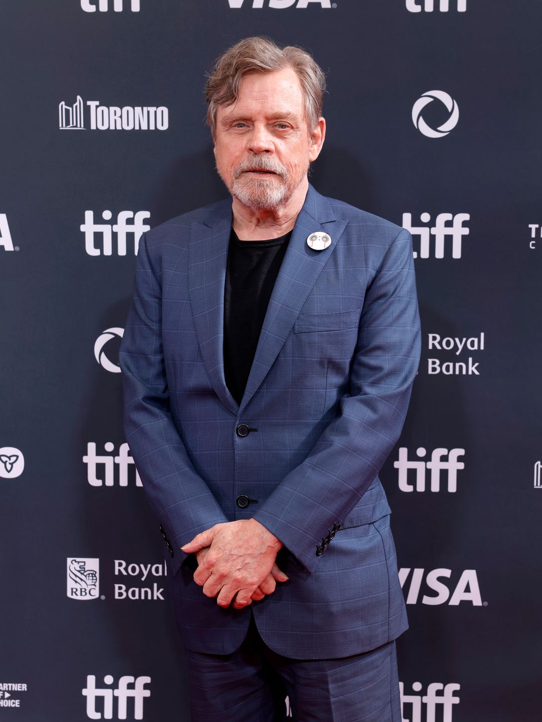 man posing in suit at premiere 