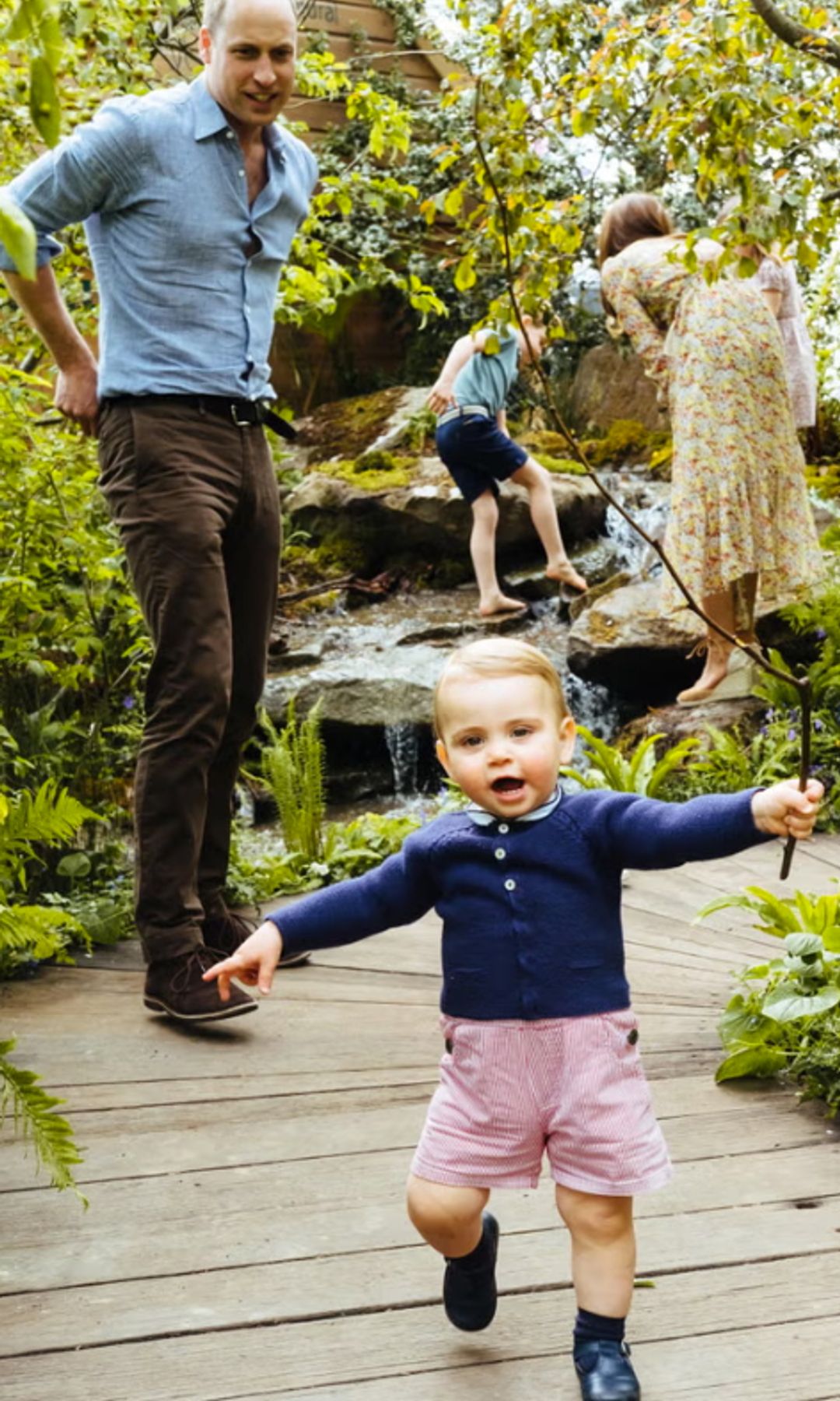 Prince Louis walking in red dungarees and blue jumper