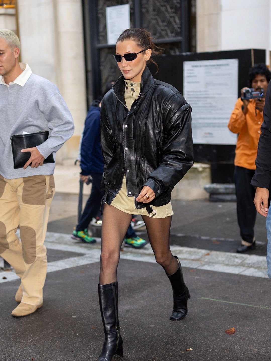 Bella Hadid is seen on September 23, 2024 in Paris, France wearing a pair of knee high boots and a leather jacket 