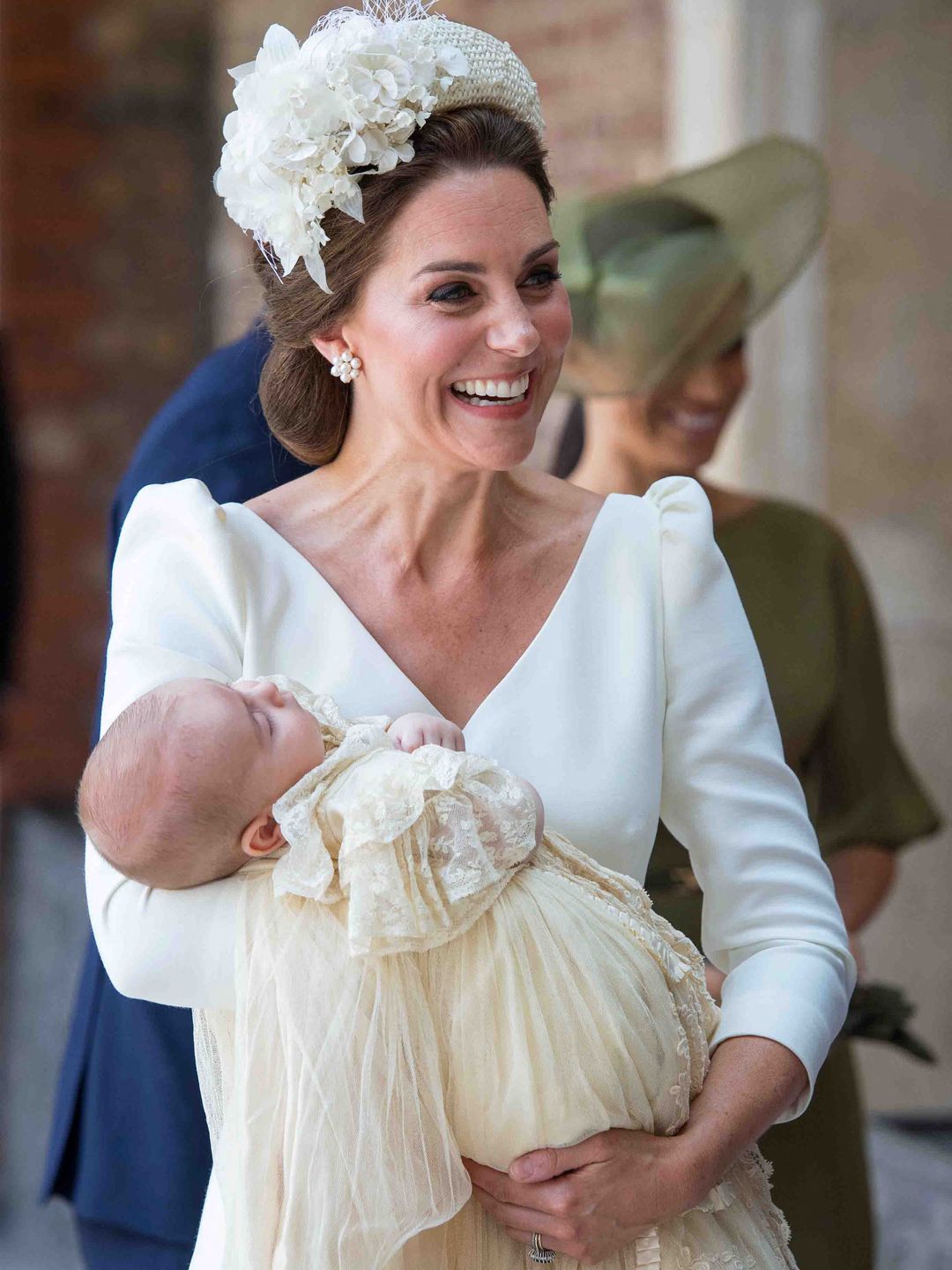 Britain's Catherine, Duchess of Cambridge holds Britain's Prince Louis of Cambridge on their arrival for his christening service wearing Alexander McQueen dress