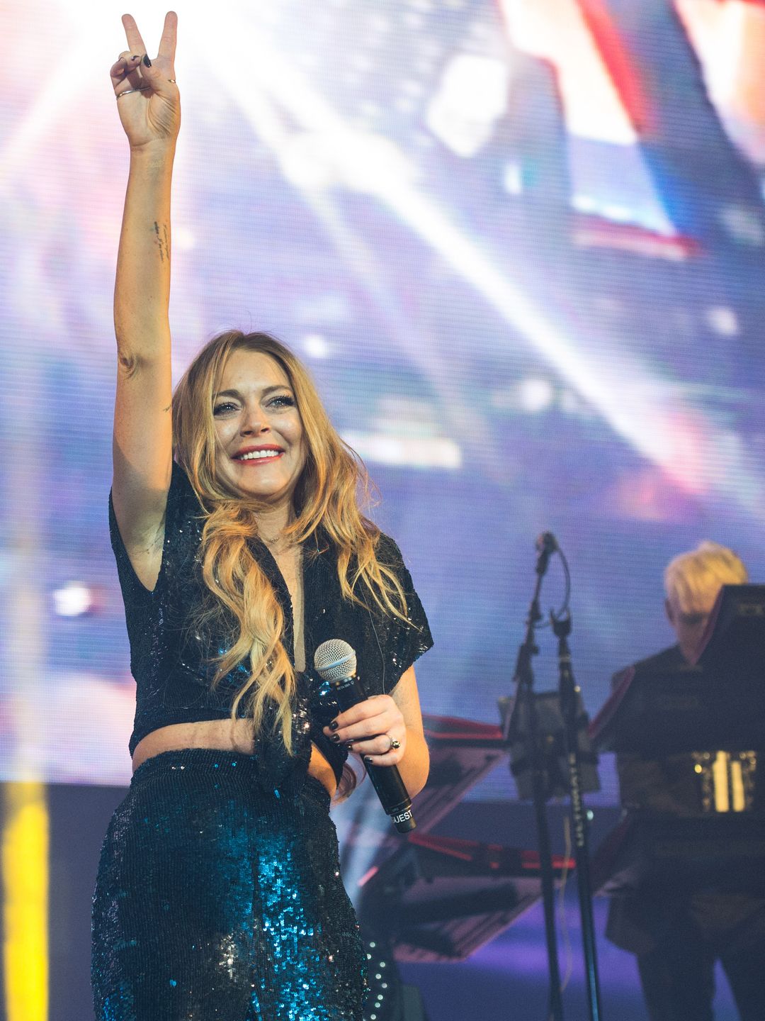  Lindsay Lohan smiling while singing on a stage