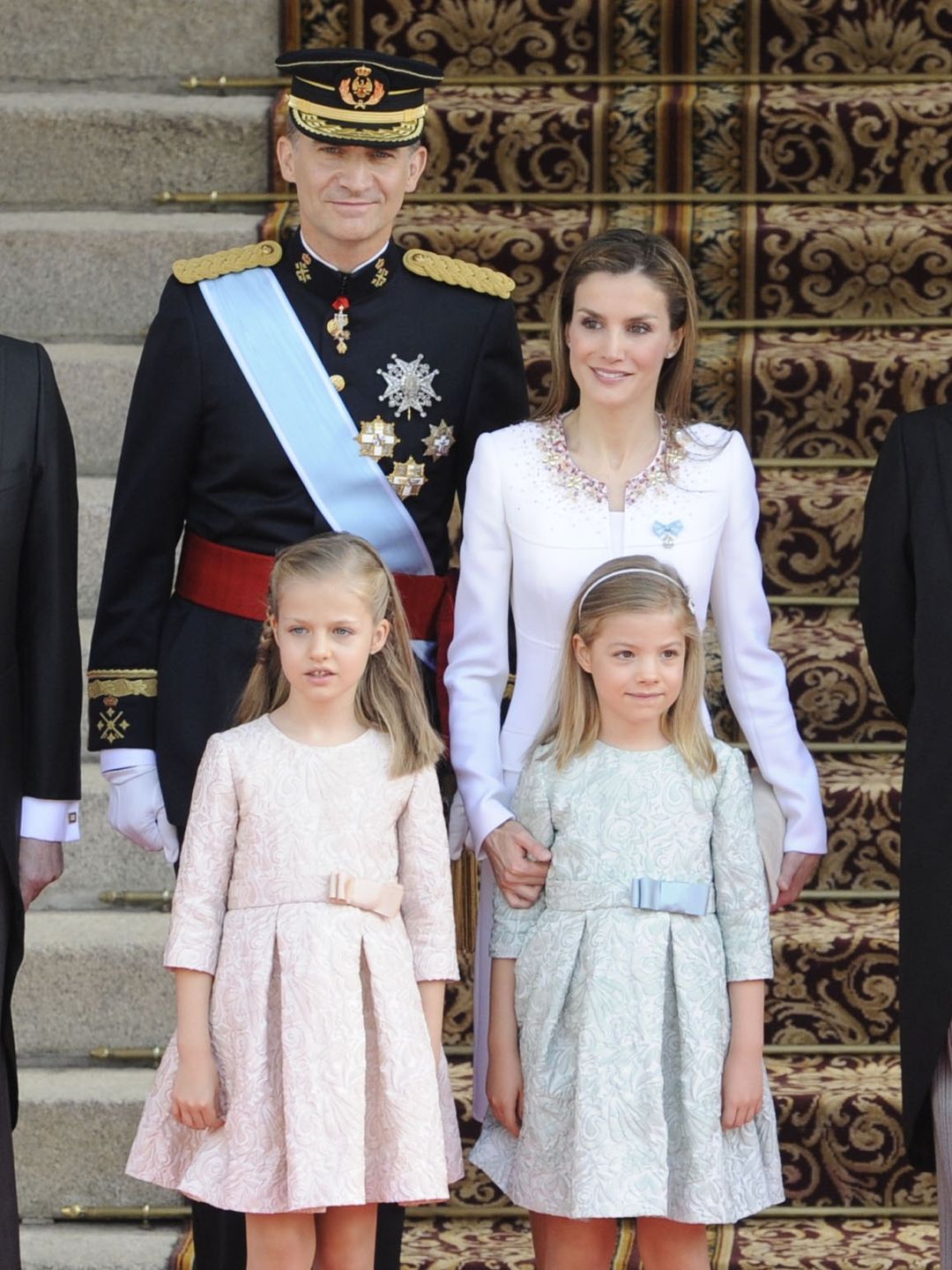 King Felipe and Queen Letizia standing behund a young Princess Leonor and Infanta Sofia