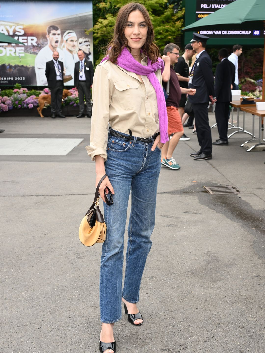 Alexa Chung wearing a beige shirt, straight-leg jeans and glossy mules 