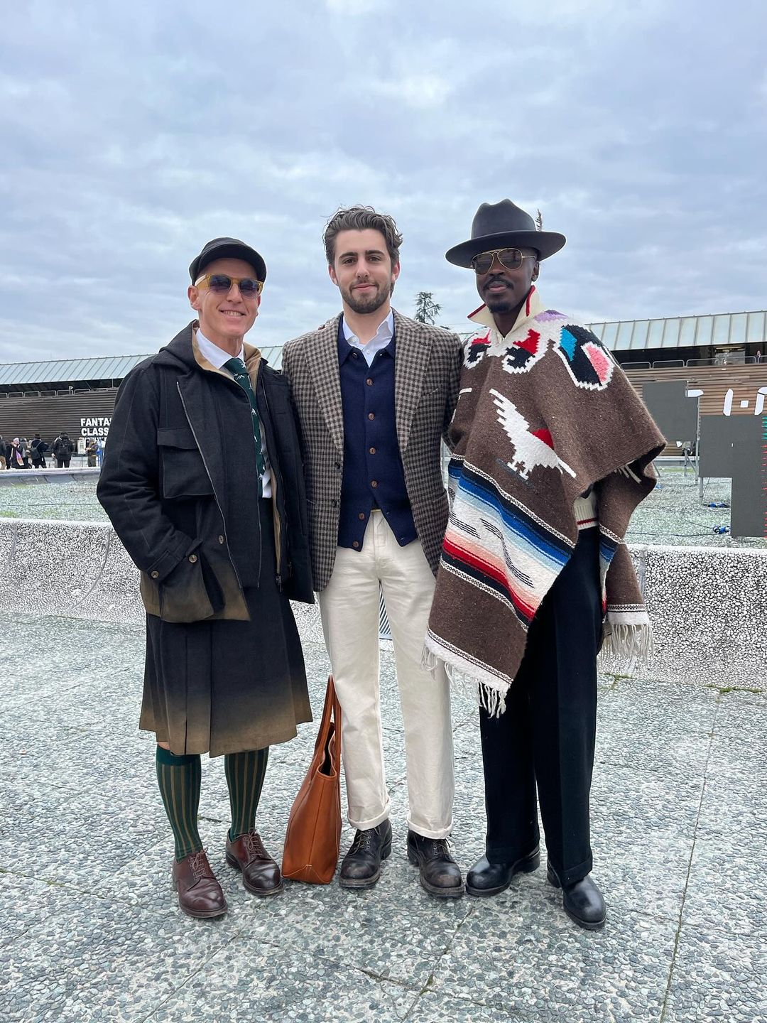 Three gentlemen pose for a photo outside the Pitti Uomo tradeshow