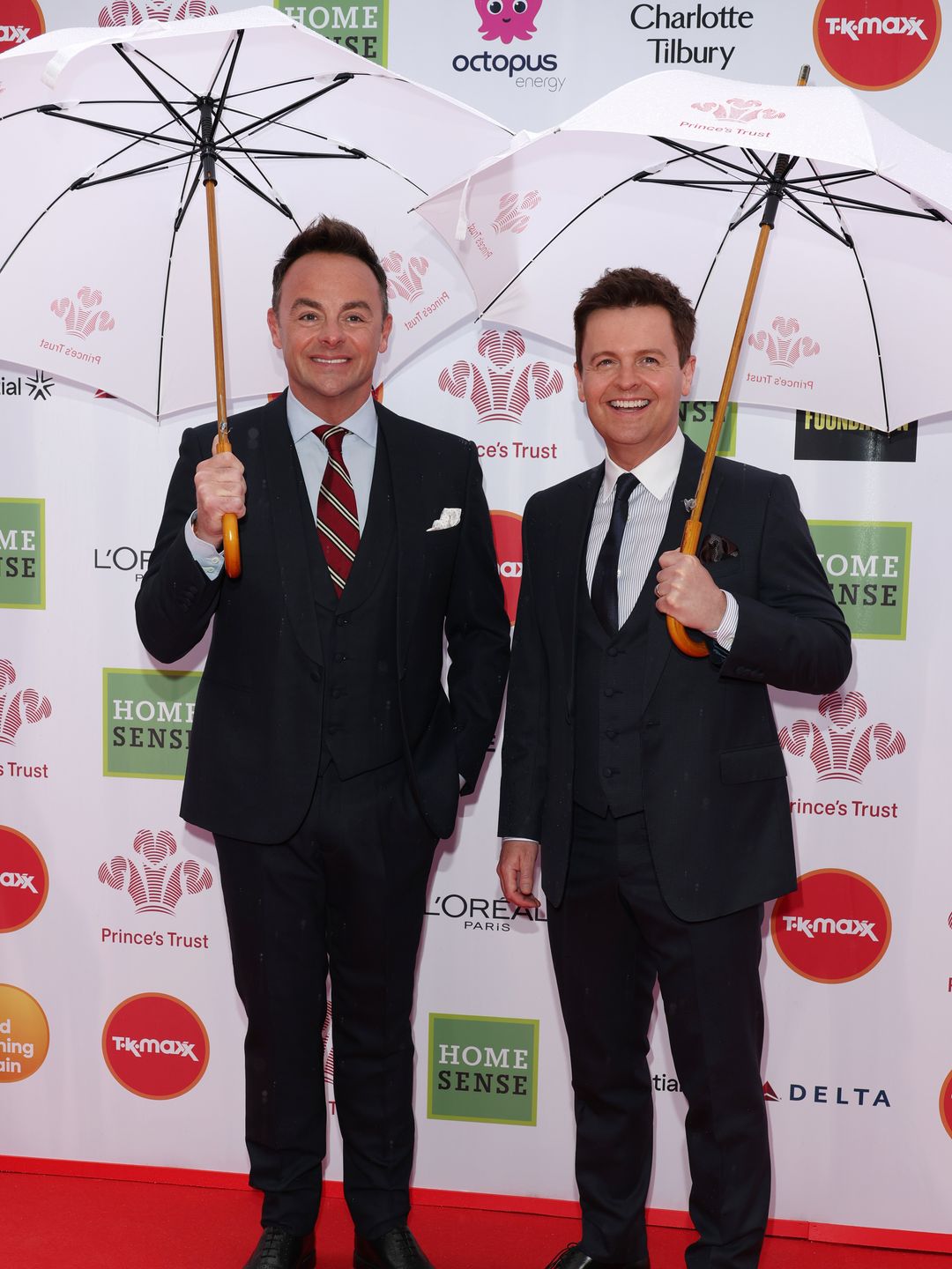 Ant and Dec in suits holding umbrellas
