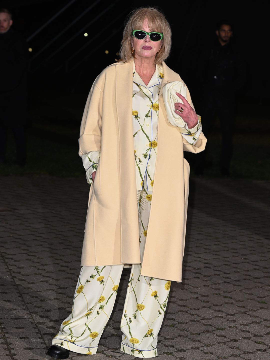 Joanna Lumley kept things casually chic at the Burberry show, donning a silk pyjama set, cream-coloured over coat and bright green framed sunglasses.