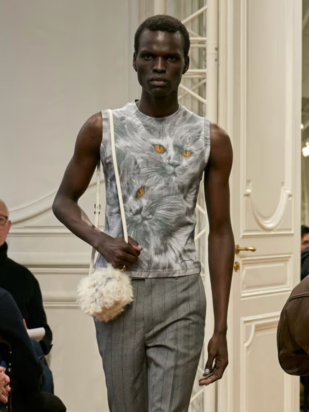 Givenchy's Menswear Fall/Winter 24 collection. A model wears grey trousers and a cat face tank top