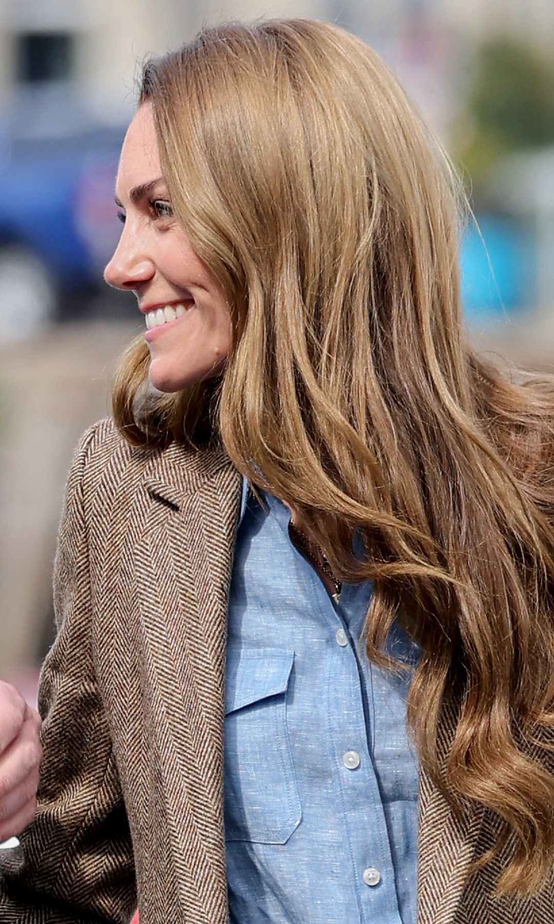 Princess Kate with long curled hair looking at Prince William