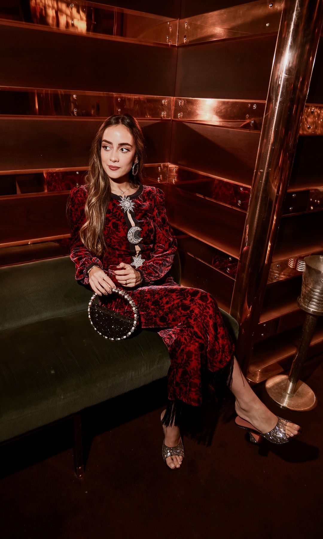 Aria Zaki dans une robe en velours rouge