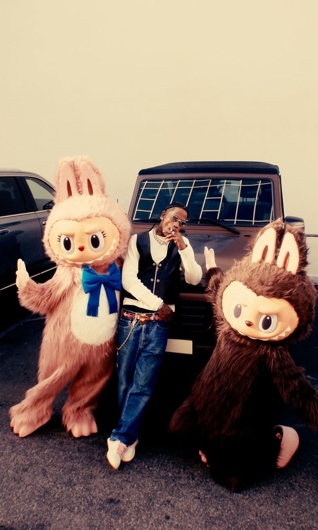 Travis Scott shares a photo of himself on Instagram posing next to two life-size Labubus in honor of his kids Stormi and Aire's birthdays