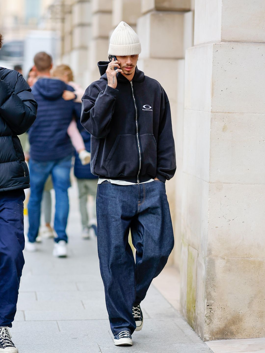 Romeo Beckham is seen on September 29, 2024 in Paris, France wearing blue jeans and a zip-up hoodie