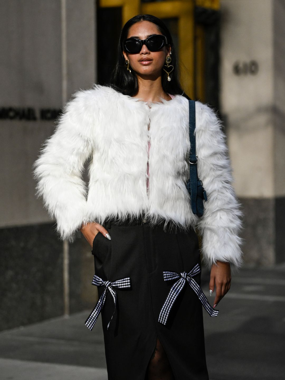 Kayla Ramos is seen wearing a faux fur white jacket, black with bow pants and black sunglasses outside the Collina Strada show
