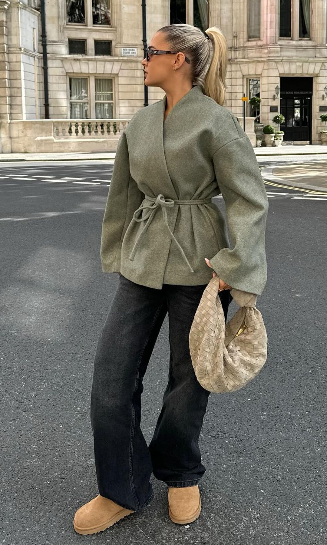 Molly-Mae poses for a photo in a grey blazer, jeans and UGG boots