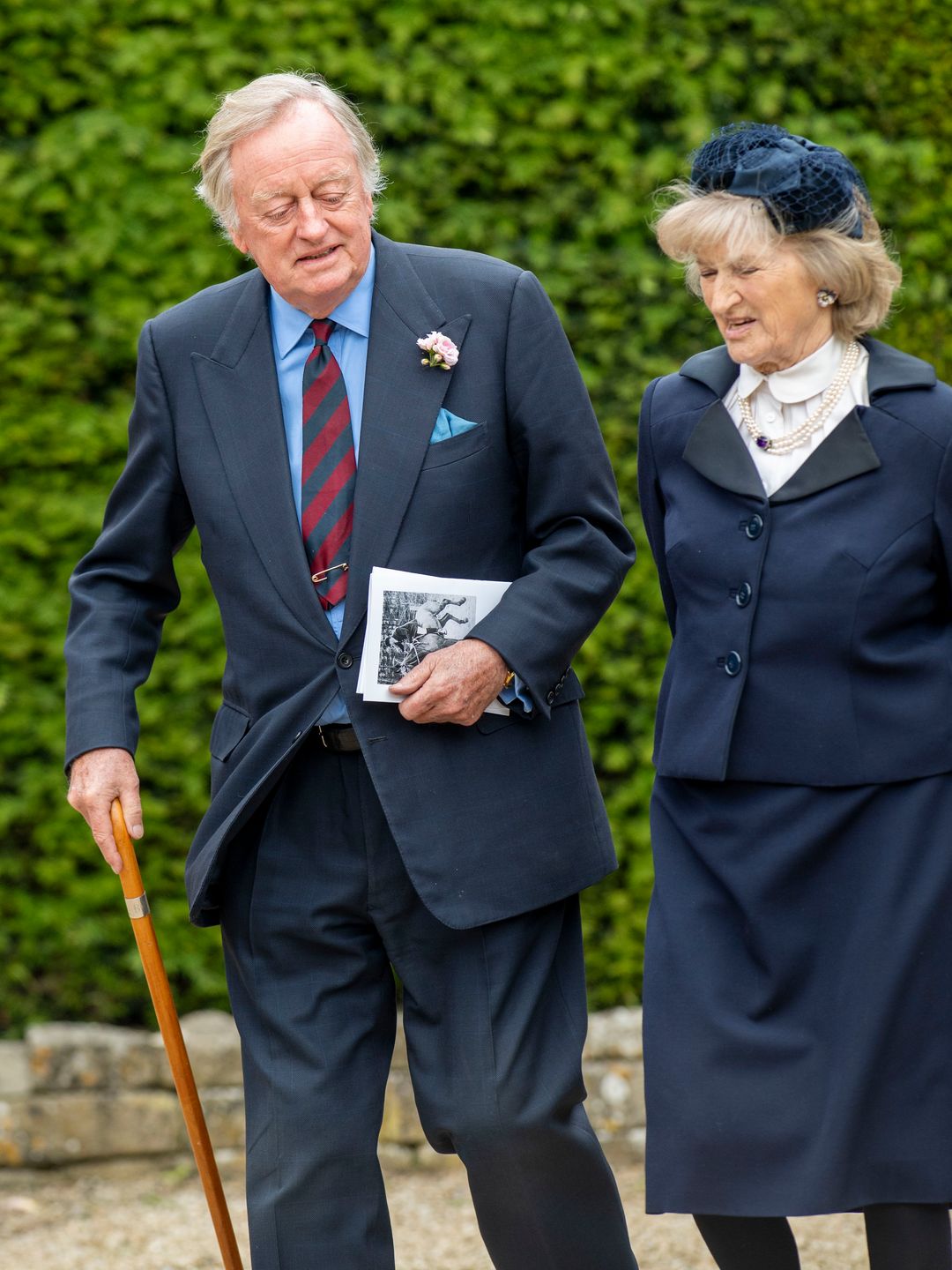 Andrew Parker Bowles walking with a walking stick and a woman
