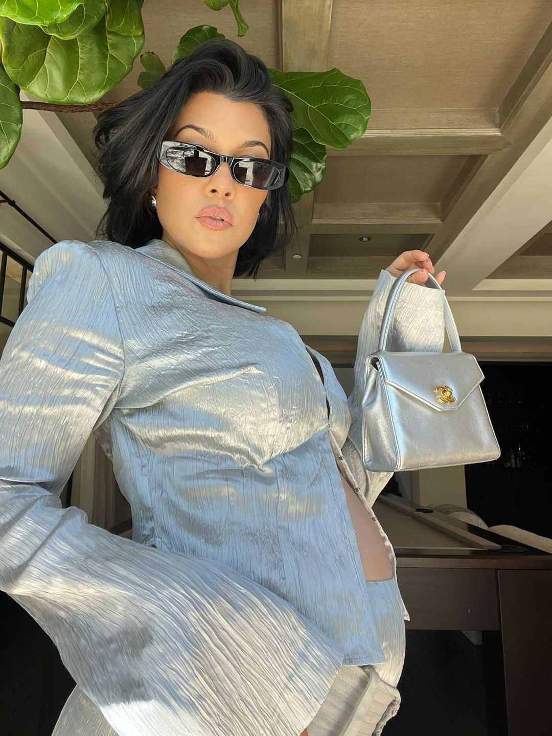 Kourtney Kardashian wearing a silver outfit 