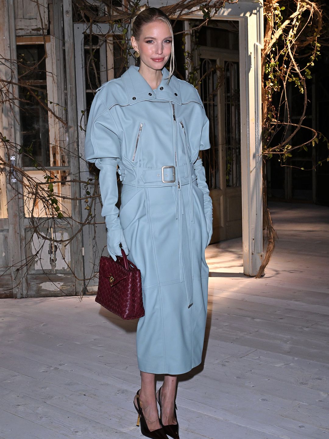 Leonie Hanne wore a baby blue leather coat and red handbag to the Antonio Marras show. 