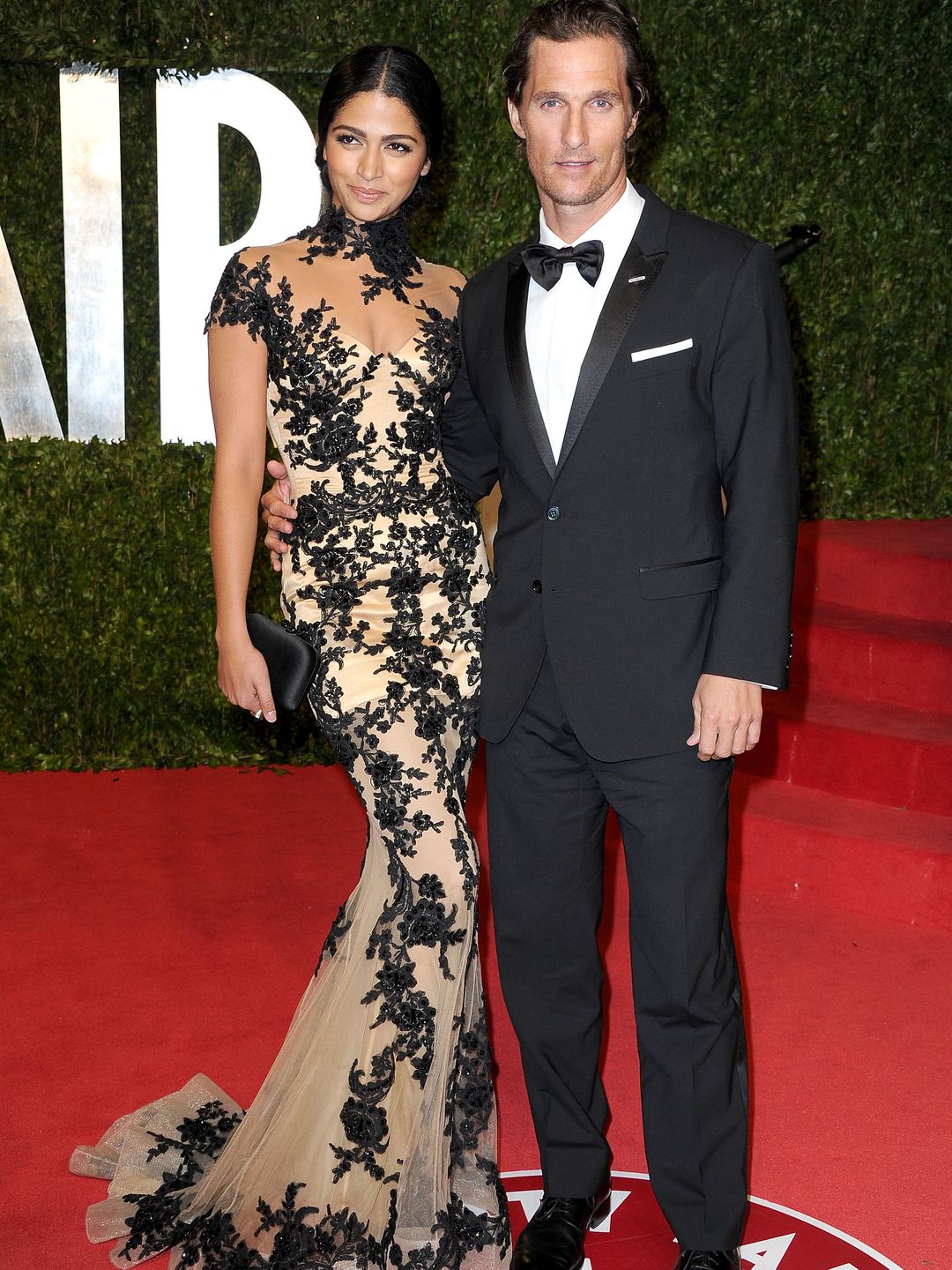 Camila Alves and Matthew McConaughey smiling for a photo on a red carpet