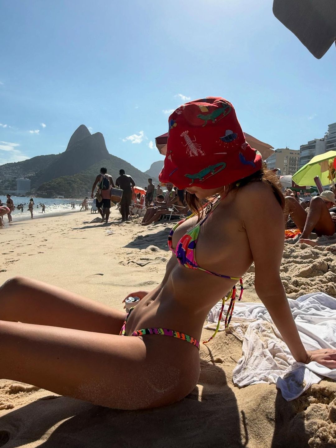 Emily Ratajkowski poses on a beach in a neon bikini