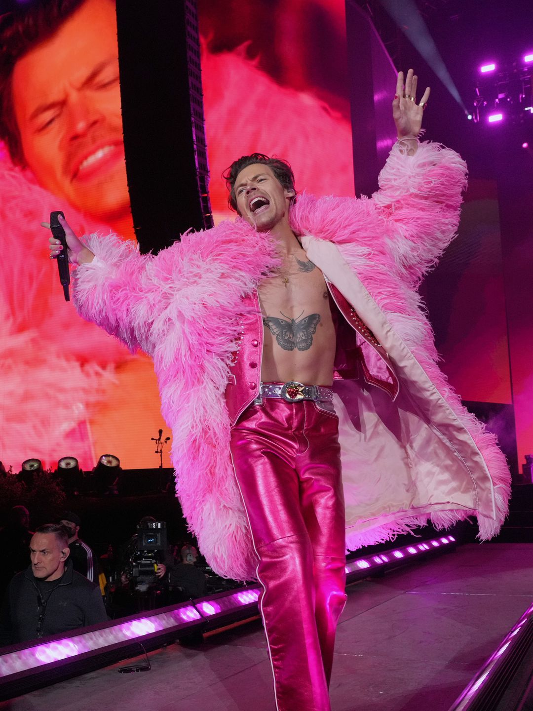 Harry Styles wears metallic pink pants and a feather coat to perform on stage at Coachella 2022