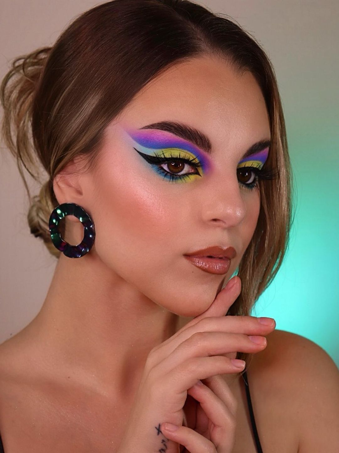 Woman with sharp colourful cut crease makeup 