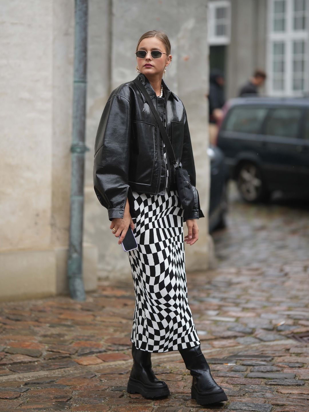 Woman wearing geometric dress with boxy leather jacket 