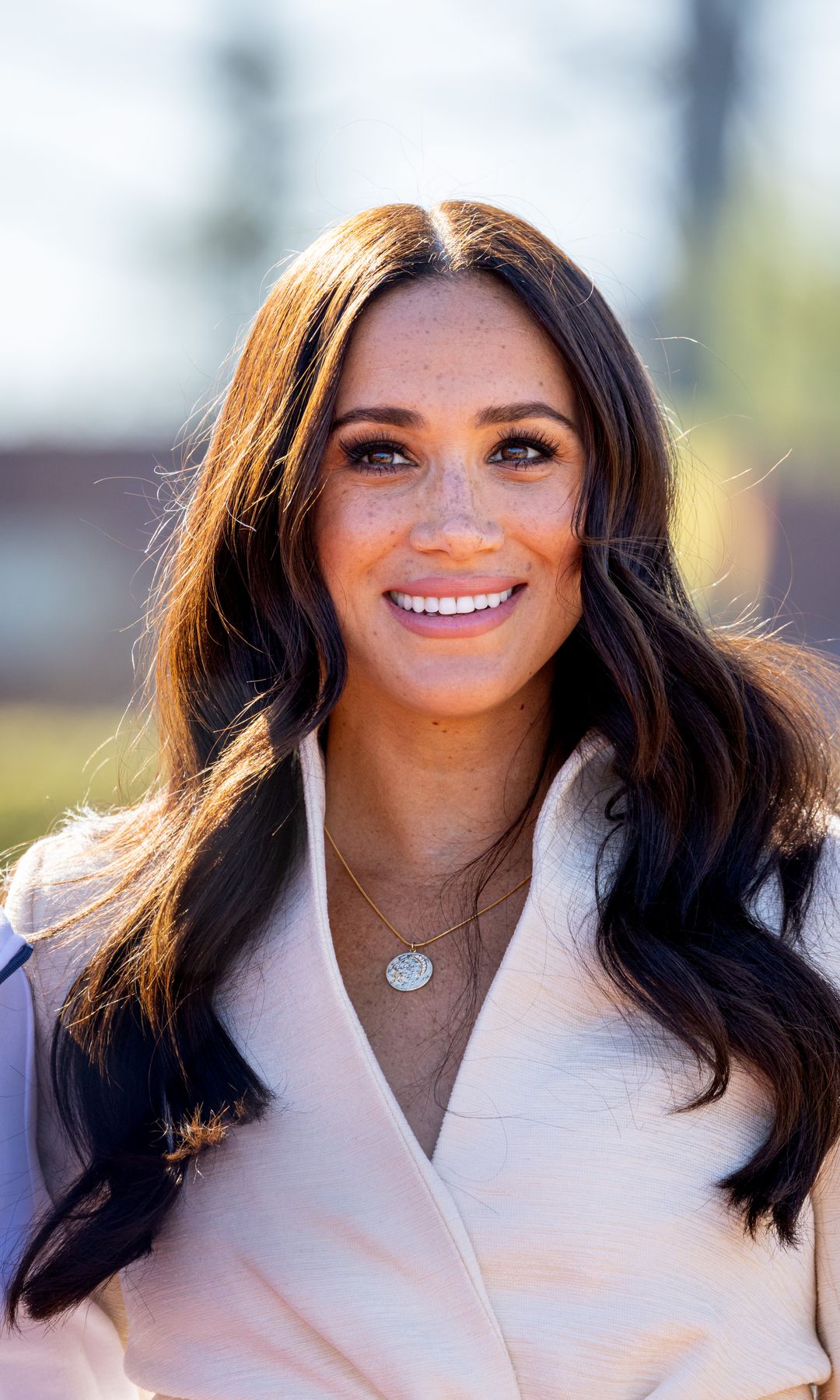 Meghan, Duchess of Sussex smiling in cream blazer