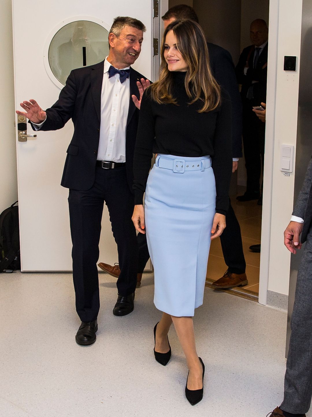 Princess Sofia of Sweden is given a tour of Stockholm University Brain Imaging Center. She wears a blue pencil skirt, heels and a black turtleneck