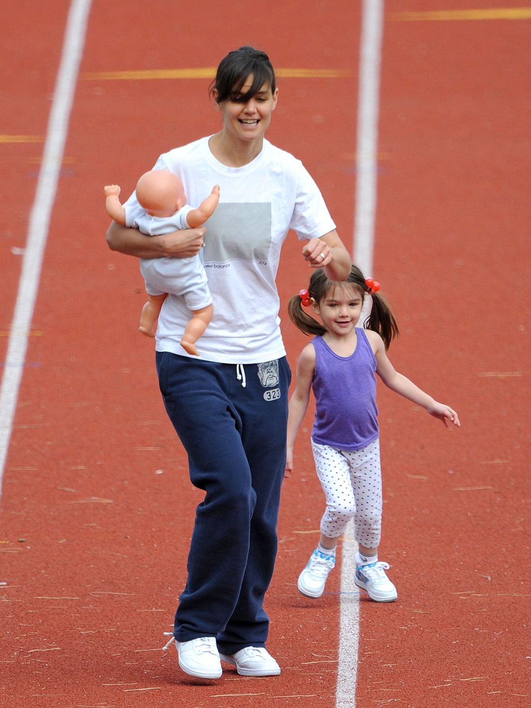 Katie Holmes et sa fille Suri Cruise courent sur un terrain d'athlétisme le 12 octobre 2009 à Boston, Massachusetts.