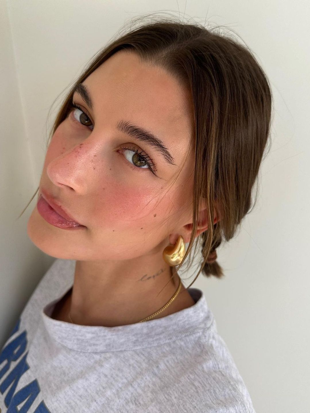 Hailey Bieber wears minimal makeup and fake freckles