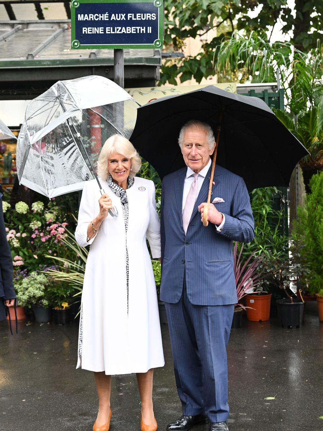 couple with umbrellas in flower market