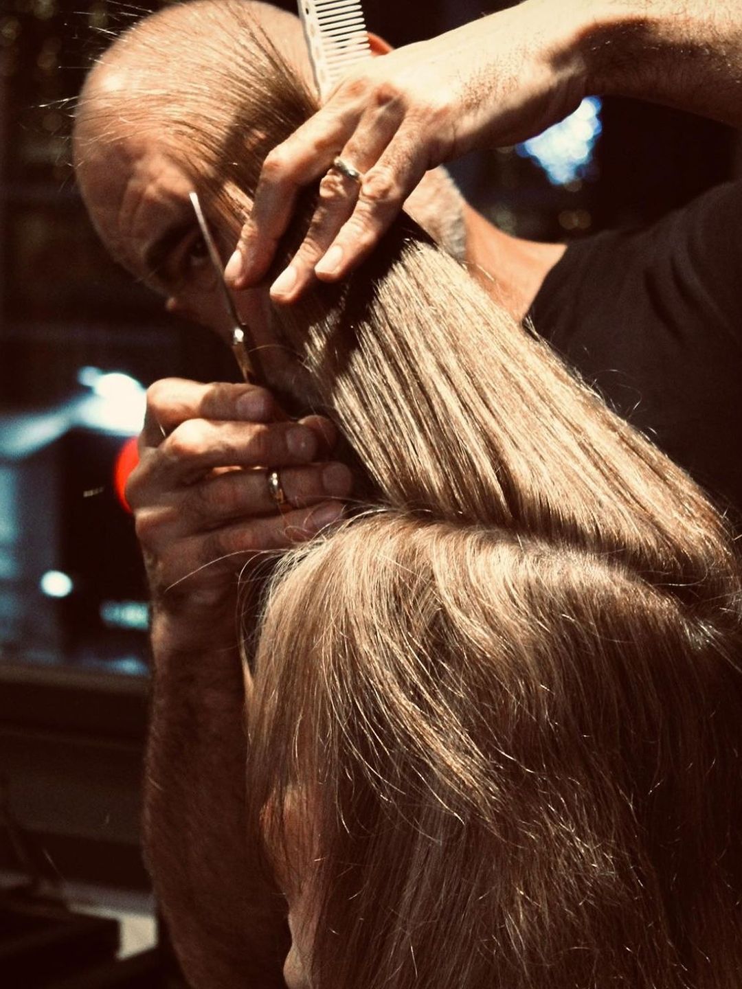 Andrew Barton cutting woman's hair