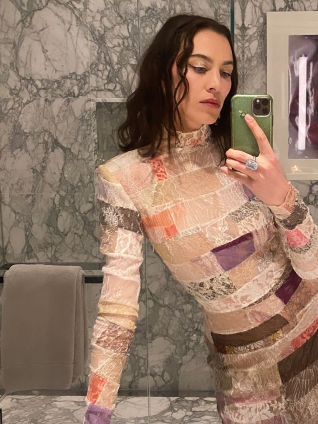 Alexa Chung taking a selfie in a high-neck patchwork dress 