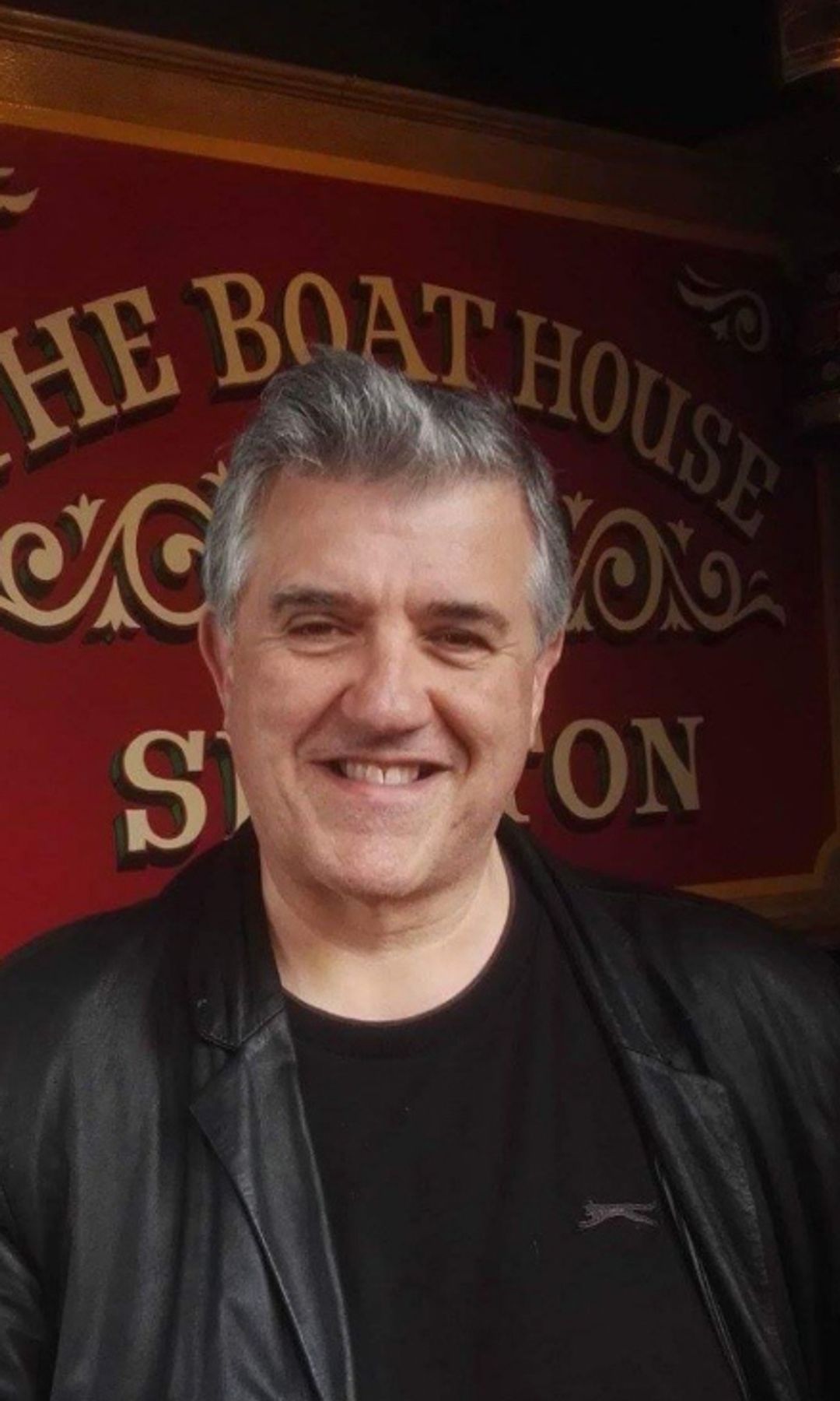 Jonathan Linsley sitting in front of a sign