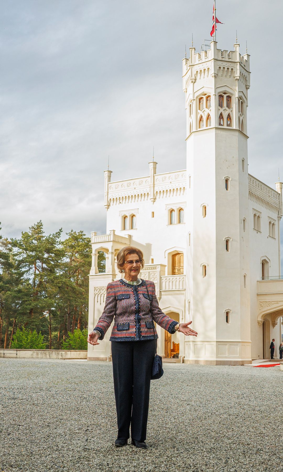 Queen Sonja standing in front of a white building
