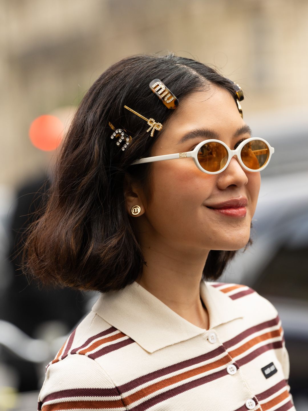 Proud Oranicha Krinchai wears Miu Miu sunglasses, hair clips and dress outside the Miu Miu show during the Womenswear Fall/Winter 2024/2025