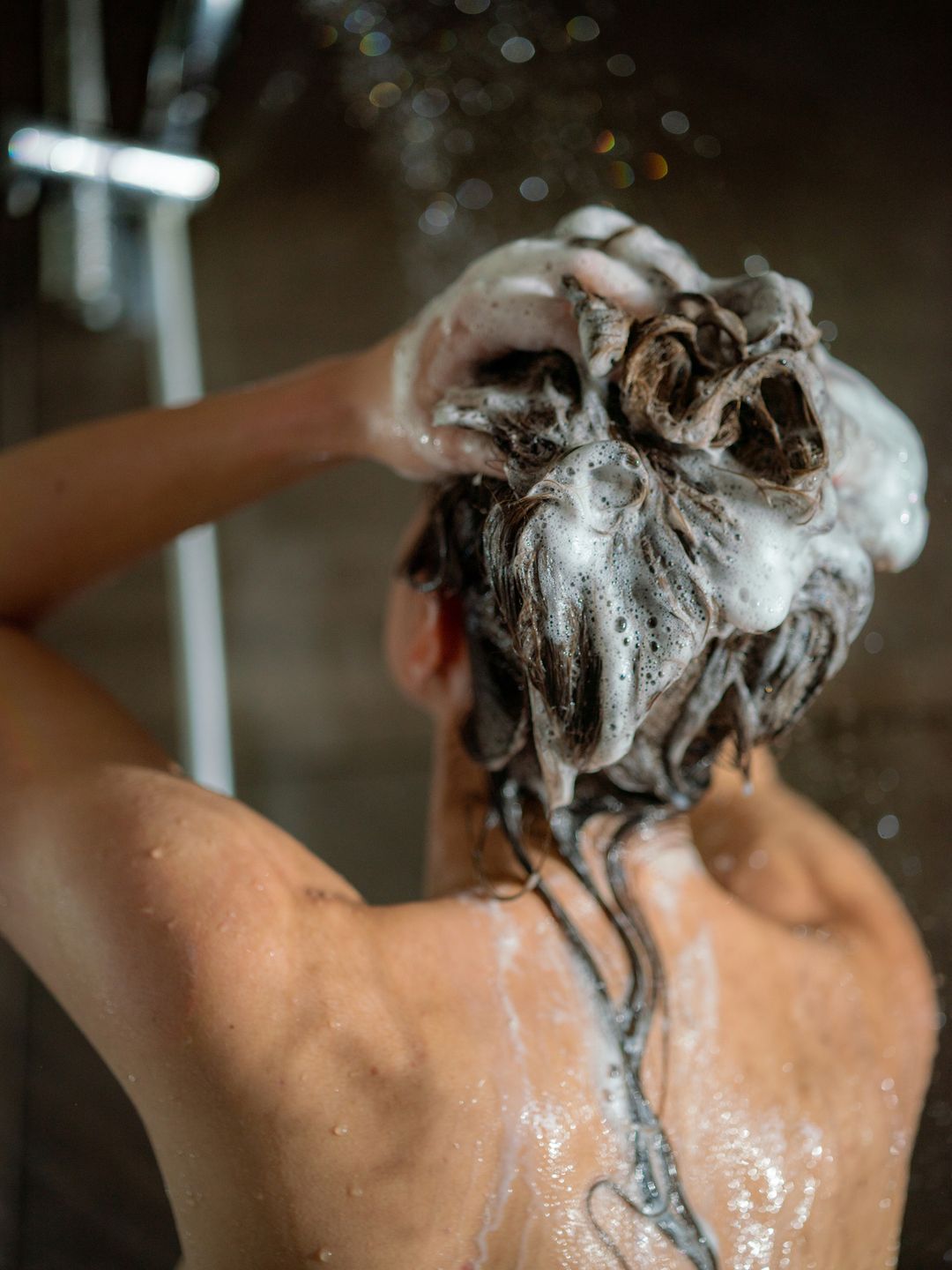 Model washing hair in shower 