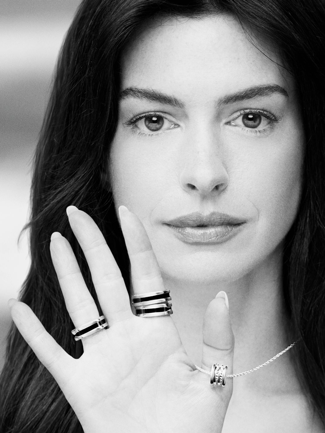Anne Hathaway showcasing the new pendant alongside original Save the Children collection rings