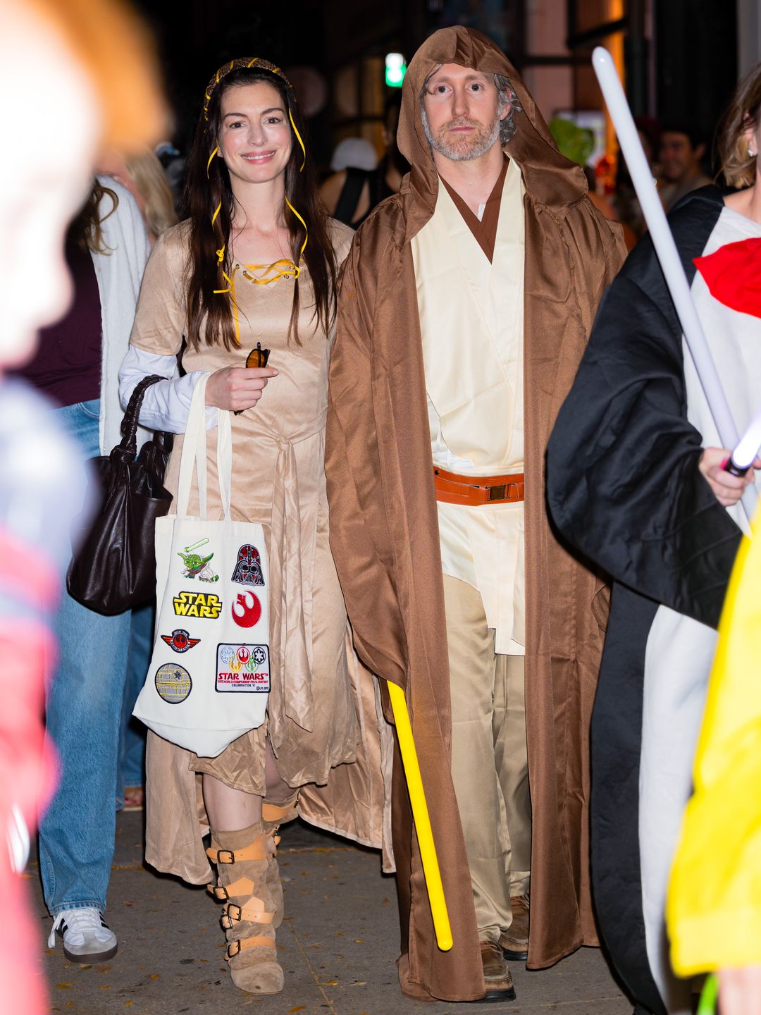 Anne Hathaway and Adam Shulman walk New York City streets dressed as "Star Wars" characters. Anne, as Princess Leia, wears a medieval-style beige dress, while Adam channels Jedi Luke Skywalker in a brown robe.