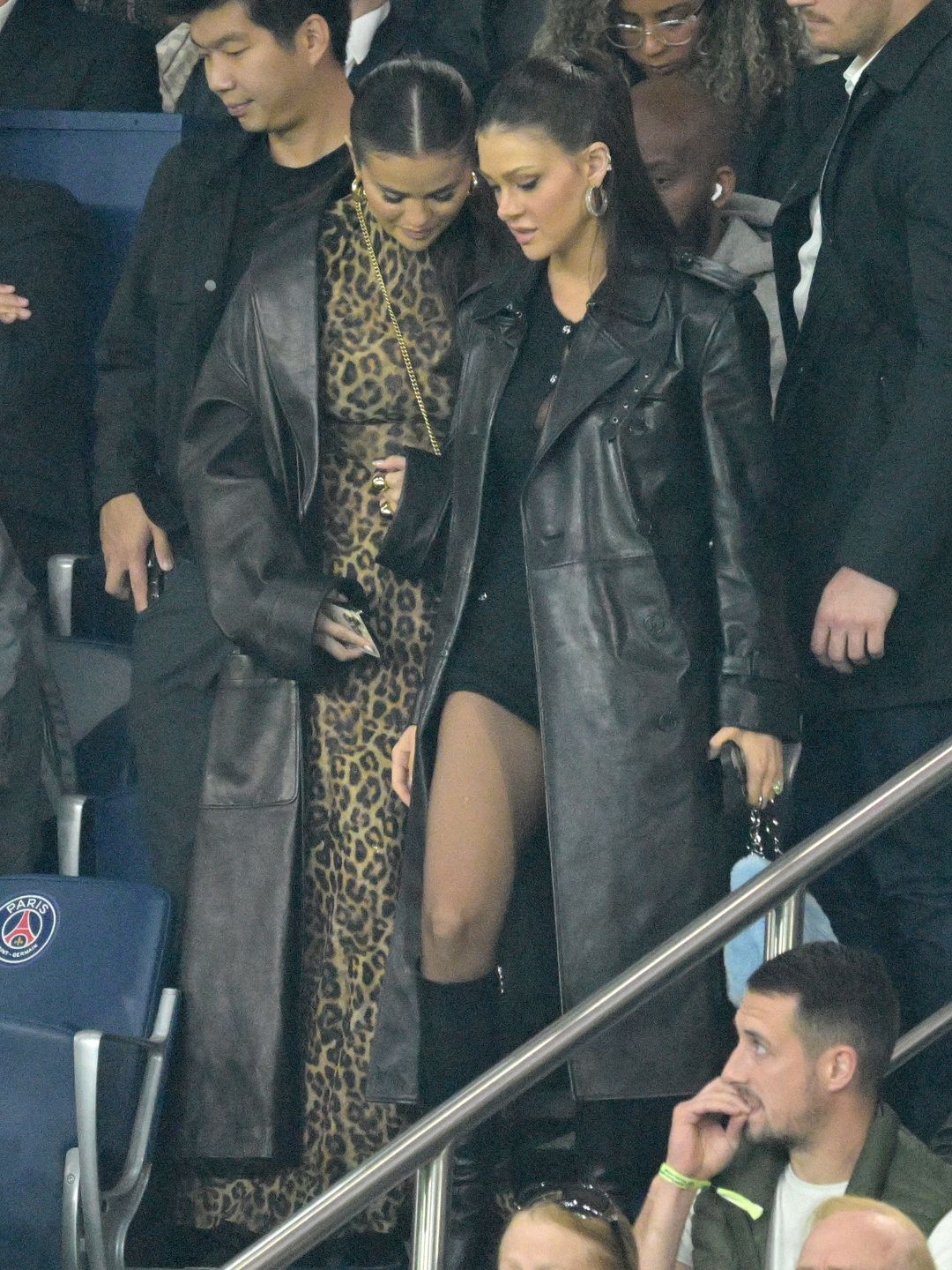 Selena Gomez and Nicola Peltz wearing leather maxi coats at the football match 