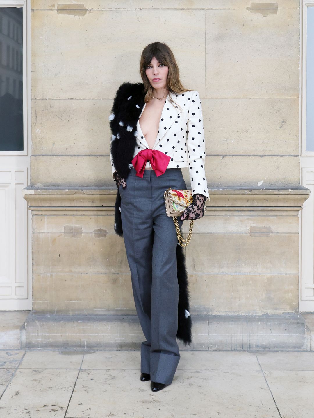 Lou Doillon rocked a plunging polka-dot blazer, gray trousers, a red bow accent, and a faux fur stole, blending Parisian chic with vintage drama.