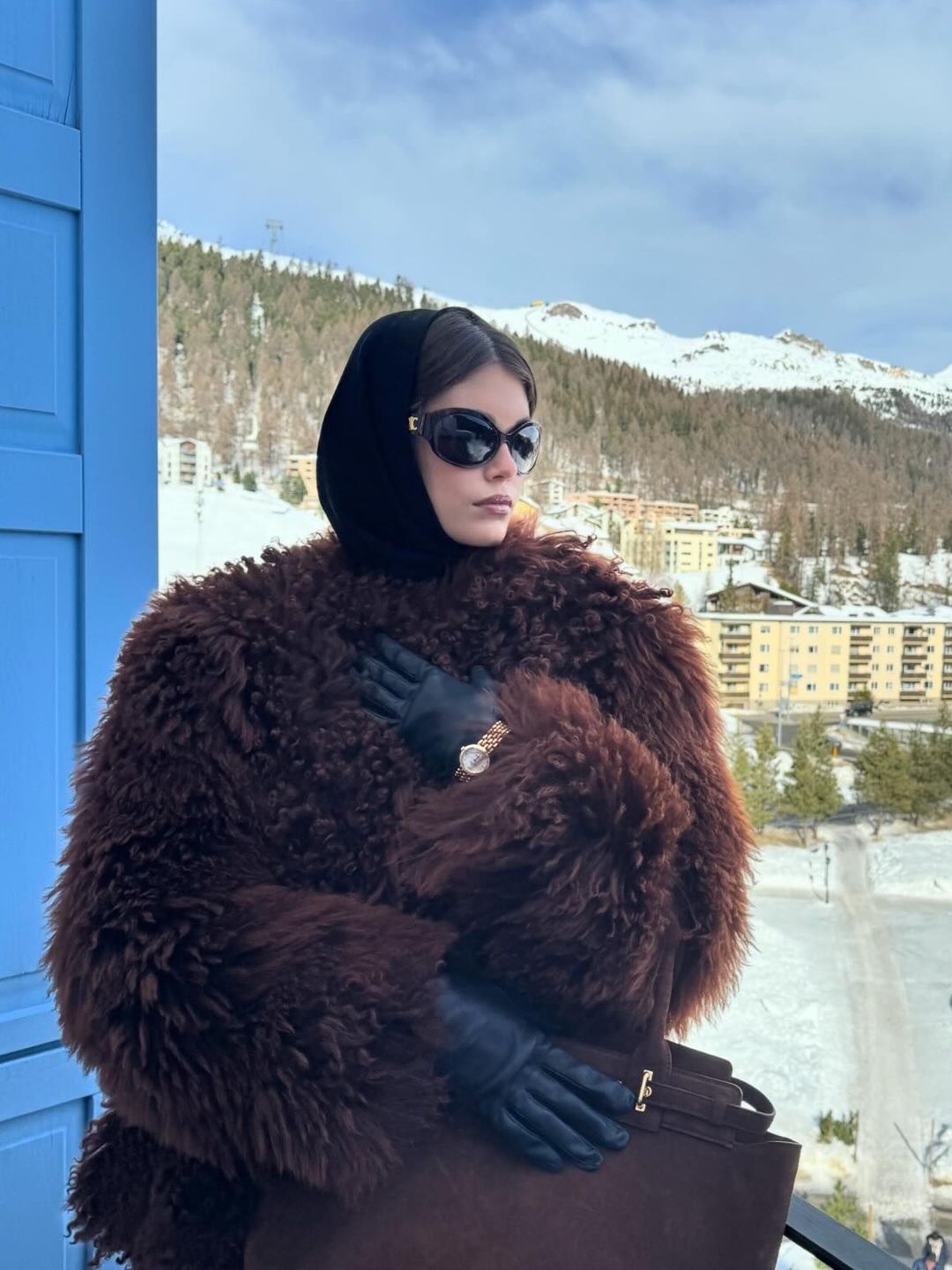 Model Kaia Gerber poses in a brown fur coat, sunglasses and leather gloves while in St Moritz