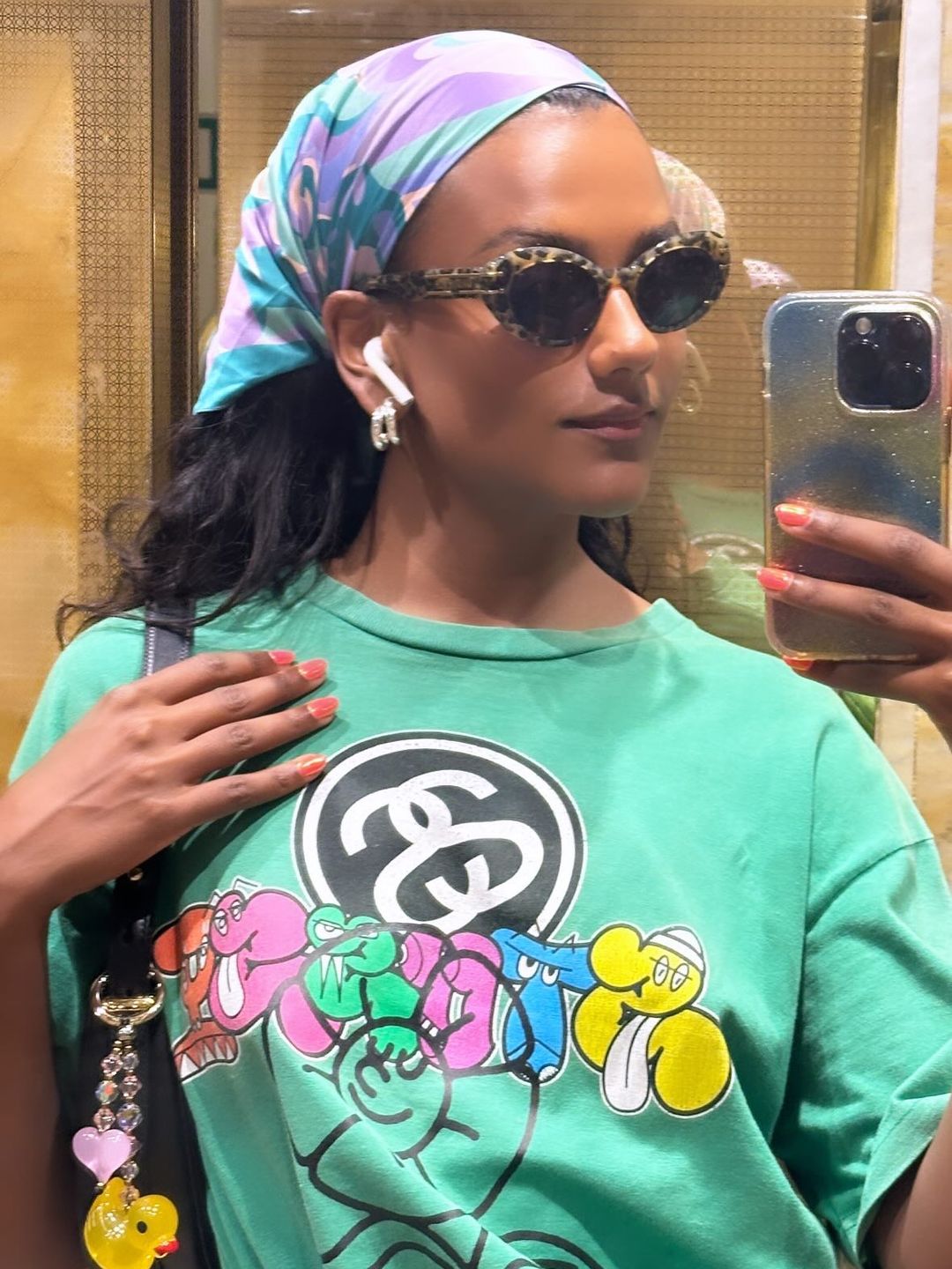 Simone Ashley posts a photo to her Instagram story wearing a green t-short and head scarf 