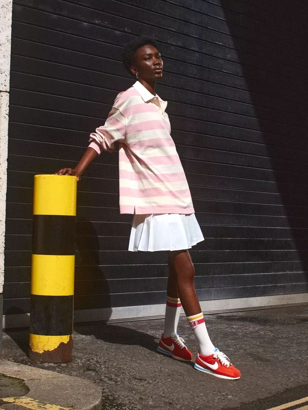 A model wears Nike Cortez shoes in red, white and blue