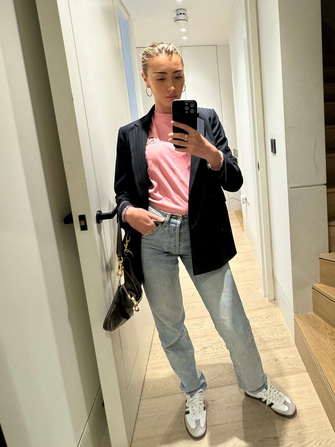 Sophie Habboo wears a pink comic relief t-shirt, Brandi Melville, white Adidas Sambas, a blue pinstriped blazer from Massimo Dutti and a brown Miu Miu bag.