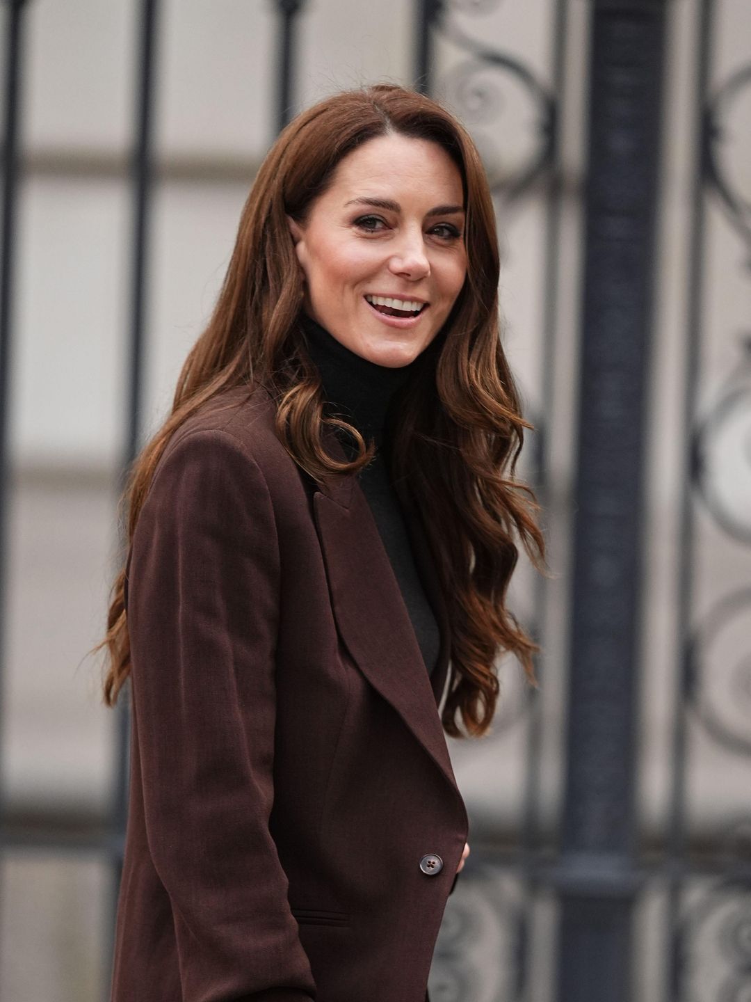 woman smiling in brown blazer