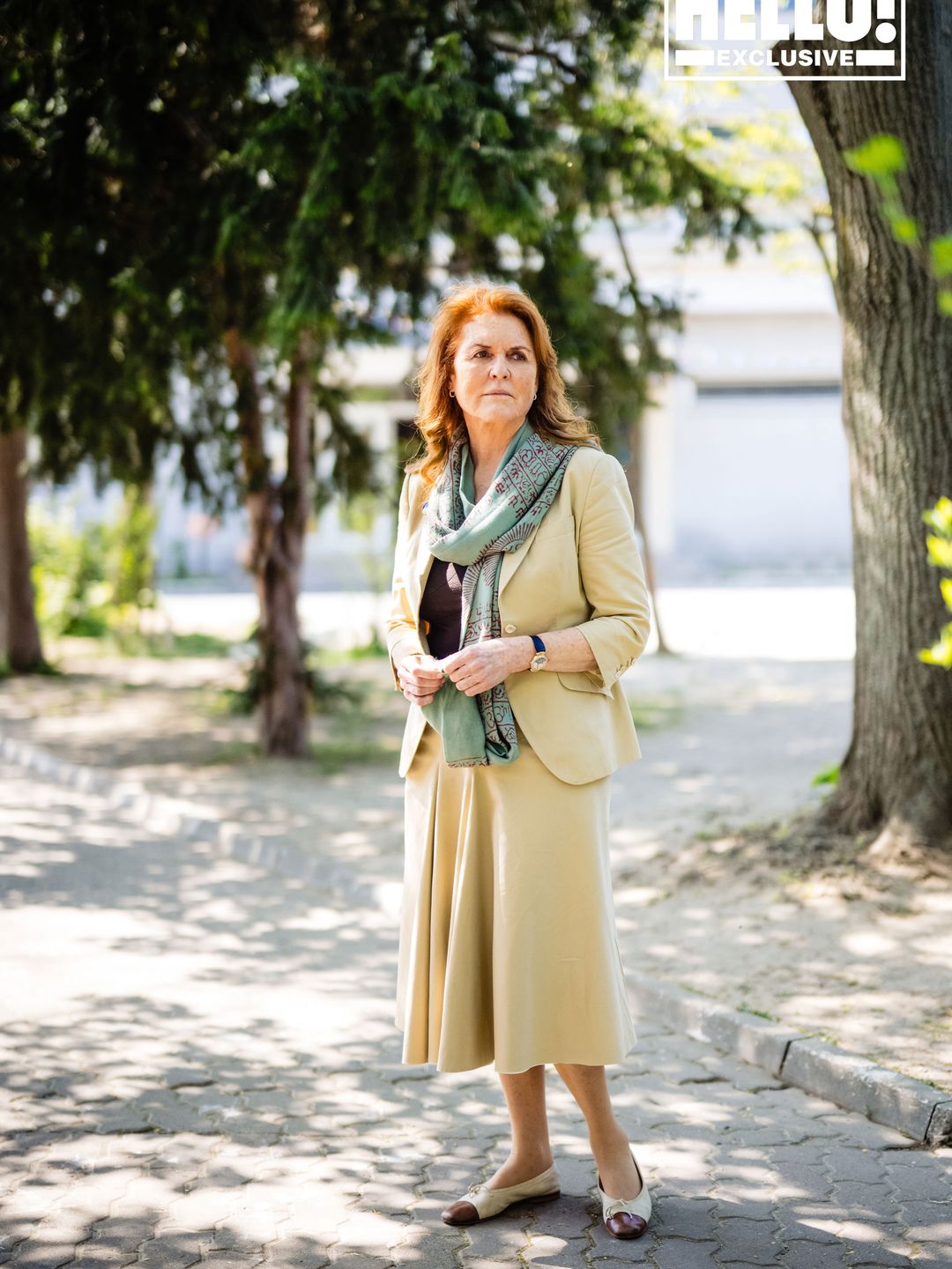 Sarah, Duchess of York wearing yellow trouser suit and scarf posing outside Tikva orphanage in Romania 